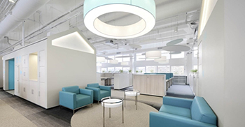 灰白色的吸音板和圆柱灯形成了员工友好的声学环境