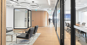 接待区的铰接木墙与侧面的玻璃隔板形成鲜明的视觉对比