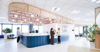 弧形中央咖啡吧在办公室入口处的“广场”中创造了一个指定地标