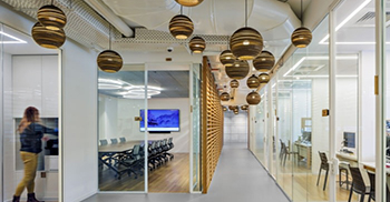 办公室装修设计：墙壁覆盖着优雅的线性木镶板 点缀着浅壁龛和搁架单元